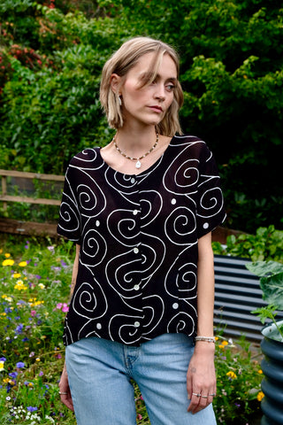 Schwarze, halbtransparente 90s Bluse aus reiner Viskose mit weißem Spiralen-Print – zu empfehlen für eine heutige M bis L