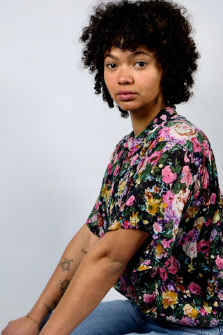 Halbtransparente 90s Hemdbluse aus reiner, leichter Viskose mit buntem Blumen Print auf schwarzem Untergrund; die Bluse hat ein besonderes und seltenes Detail: kleine seitliche Eingrifftaschen unten (s. letztes Foto), ist insgesamt eher länger und locker geschnitten – wir empfehlen die Bluse einer L bis XL