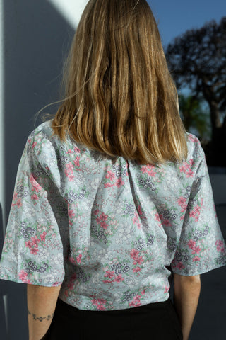 Traumhafte, hellblaue 80s Bluse von der Designermarke Cacharel, made in Italy aus reiner und leichter Baumwolle, mit floralem Print in Hellgrün, Rosa/Pink, Flieder/Lila und Weiß – ca. von einer M bis XL tragbar je nach gewünschter Passform (bitte Maße beachten) – ein sehr seltenes Fundstück und Designer-Highlight