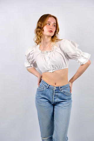 Traumhafte weiße 80s Folklore Dirndlbluse in typisch verkürztem Schnitt mit Gummizugsaum, tollen Puffärmeln und Details aus Lochspitze – made in Germany/Bavaria und ca. tragbar von einer XS bis S je nach gewünschter Passform (bitte Maße beachten) – ein absolutes Highlight