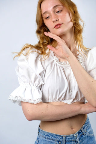 Traumhafte weiße 80s Folklore Dirndlbluse in typisch verkürztem Schnitt mit Gummizugsaum, tollen Puffärmeln und Details aus Lochspitze – made in Germany/Bavaria und ca. tragbar von einer XS bis S je nach gewünschter Passform (bitte Maße beachten) – ein absolutes Highlight