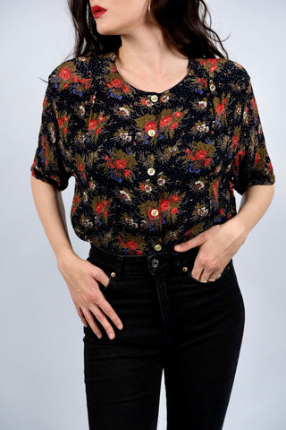 Schwarze/Blauschwarze 90s Bluse aus reiner, halbtransparenter Viskose mit kleinen Polka Dots und floralem Muster in Rot, Weiß, Blau, Rotbraun, Grau und Oliv – wir empfehlen die Bluse einer L bis XL
