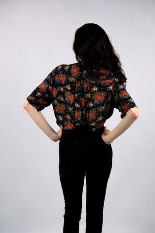 Schwarze/Blauschwarze 90s Bluse aus reiner, halbtransparenter Viskose mit kleinen Polka Dots und floralem Muster in Rot, Weiß, Blau, Rotbraun, Grau und Oliv – wir empfehlen die Bluse einer L bis XL