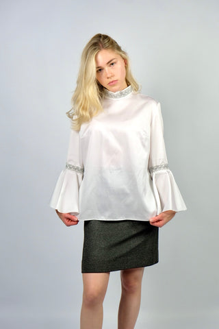 Weiße 70s Bluse mit Stehkragen, Trompetenärmeln und silbernen Verzierungen, wird am Rücken mit einer Knopfleiste geschlossen – wir empfehlen die Bluse einer heutigen S bis M – ein seltenes Fundstück und absolutes Highlight