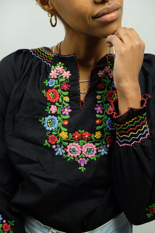 Schwarze, eher kurz geschnittene 90s Bluse im 70er-Boho-Stil mit tollen floralen Stickereien und leichten Ballonärmeln – ein absolutes Highlight