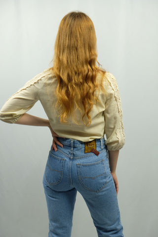 70s Bluse in Creme/Beige mit hübschen Details aus Häkelspitze – die angegebene Größe ist 36 (S), wir empfehlen die Bluse jedoch eher einer XS – ein absolutes Highlight