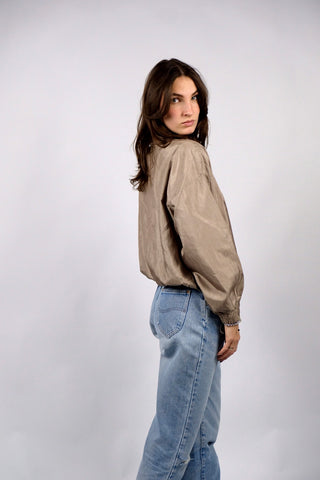 80s Bluse in tollem Bomber-/Blouson-Schnitt mit Stehkragen und Schulterpolstern (welche bei Bedarf auch herausgetrennt werden könnten); die Farbe würden wir als Oliv-Gold bezeichnen, die angegebene Größe ist L – tragbar von M bis L