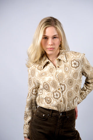 Cremefarbene 70s Bluse mit tollem Boho-Blumenmuster in Beige und Braun, die Größe entspricht ca. einer heutigen M bei einer für die 70s typischen figurbetonten/engen Passform – für einen eher lockeren Look empfehlen wir die Bluse aber einer XS oder S – bitte Maße beachten