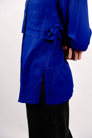 90s Avantgarde Bluse aus reiner Viskose in leuchtendem Royalblau mit fließendem Fall – einzigartige zweilagige Layering-Optik mit Seitenschlitzen, aufgesetzten Taschen und seitlichen Schleifen-Details zum Binden – bewusst locker geschnittene Größe XS, ebenfalls von einer S tragbar und auch offen als leichte Jacke ein echter Hingucker – ein absolutes Highlight