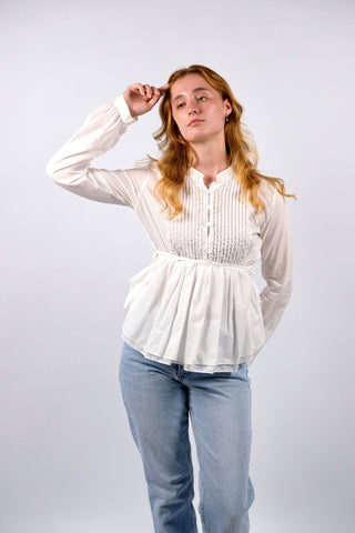 Traumhafte, weiße Preloved (Secondhand) Premium Babydoll-Bluse des italienischen Luxuslabels Dondup (made in Italy). Aus hauchzarter, reiner Baumwolle gefertigt, mit plissierter Brustpartie, leichten Ballonärmeln, kleinem Stehkragen und femininem Schößchen in zweilagigem Design, das sich mit feinen Bändern taillieren lässt – entspricht einer deutschen M und ist auch von einer S tragbar (bitte Maße beachten) – ein absolutes Designer-Highlight