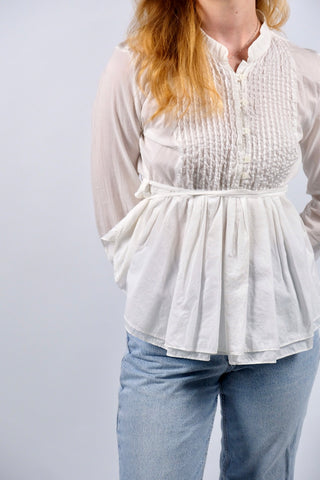 Traumhafte, weiße Preloved (Secondhand) Premium Babydoll-Bluse des italienischen Luxuslabels Dondup (made in Italy). Aus hauchzarter, reiner Baumwolle gefertigt, mit plissierter Brustpartie, leichten Ballonärmeln, kleinem Stehkragen und femininem Schößchen in zweilagigem Design, das sich mit feinen Bändern taillieren lässt – entspricht einer deutschen M und ist auch von einer S tragbar (bitte Maße beachten) – ein absolutes Designer-Highlight