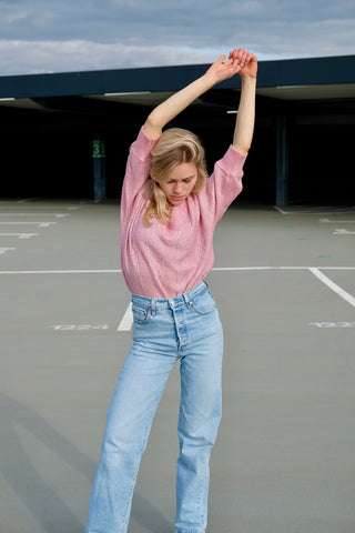80s Pullover in lockerem Schnitt mit halblangen Ärmeln und V-Kragen, die Farbe ist ein helles Rosa mit silbernen Glitzerfäden – wir empfehlen den Pullover einer XS bis S je nach gewünschter Passform